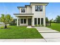 Modern two-story home featuring minimalist landscaping, well-manicured lawn, and a glass front door at 1733 Harmon Ave, Winter Park, FL 32789