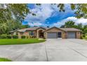 Charming brick home featuring a well-manicured lawn and a three-car garage at 1879 Odham Dr, Deltona, FL 32738