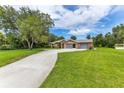Sprawling front lawn leading to a brick home with an attached three-car garage at 1879 Odham Dr, Deltona, FL 32738