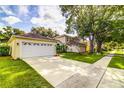 House featuring a well-maintained lawn and convenient two-car garage, ensuring ample parking at 2031 Wekiva Reserve Blvd, Apopka, FL 32703