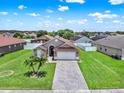 Aerial view of a charming one-story home with a paved driveway and lush landscaping at 2713 Eagle Glen Cir, Kissimmee, FL 34746