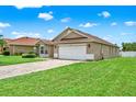 Exterior view of a one-story home featuring a two-car garage and well-maintained landscaping at 2713 Eagle Glen Cir, Kissimmee, FL 34746