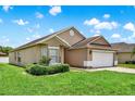 Side view of a cozy one-story home with a lush green lawn and a paved driveway at 2713 Eagle Glen Cir, Kissimmee, FL 34746