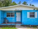 A blue house featuring a white door, white diamond-shaped gable decoration, and an ADT security sign at 2728 Hertha Ave, Orlando, FL 32826