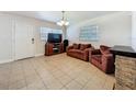 Comfortable living room featuring neutral tile flooring, plenty of seating, and natural light from the windows at 2728 Hertha Ave, Orlando, FL 32826