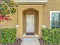 Inviting entryway featuring a white door with sidelights and decorative bushes at 3010 Secret Lake Dr, Kissimmee, FL 34747