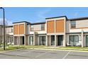 Street view of modern townhome exteriors with a parking lot in front of the building at 3308 Tranquil Trl, Kissimmee, FL 34747