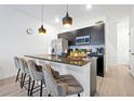 Modern kitchen features black cabinets, granite countertops, and a large island with seating at 3308 Tranquil Trl, Kissimmee, FL 34747