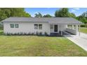 Charming single-story home with a modern white exterior, covered entry, and well-maintained lawn at 36 Morning Glory Dr, Debary, FL 32713