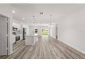 Bright, open-concept living space with wood floors, a kitchen island, and natural light streaming through sliding doors at 4345 Sw 143Rd Lane Rd, Ocala, FL 34473
