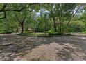Circular driveway with a gravel surface surrounded by lush landscaping and mature trees at 4702 Shorecrest Dr, Orlando, FL 32817