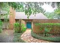 Charming front entrance with a brick wall, stone walkway, and vibrant blue double doors at 4702 Shorecrest Dr, Orlando, FL 32817