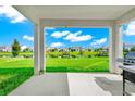 Serene backyard with lake view framed by covered patio columns, includes a grill for outdoor cooking at 4908 Lotta Ct, St Cloud, FL 34772