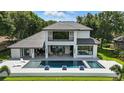 A modern backyard featuring a large pool, spa, and covered patio, perfect for outdoor relaxation and entertaining at 5074 Isleworth Country Club Dr, Windermere, FL 34786