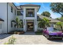Luxury home featuring a unique gold accented door, pristine landscaping, and a paved drive leading to the grand entrance at 5074 Isleworth Country Club Dr, Windermere, FL 34786