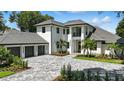 Elegant two-story house with a three-car garage and a spacious, paved driveway surrounded by well-maintained landscaping at 5074 Isleworth Country Club Dr, Windermere, FL 34786