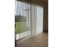 Enclosed patio area with vertical blinds and a serene view of the backyard at 512 Novara Way, Davenport, FL 33837