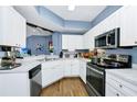 Bright kitchen featuring white cabinets, stainless steel appliances, and a convenient corner layout at 5566 Metrowest Blvd # 10, Orlando, FL 32811