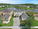 Lovely two-story home with manicured lawn located on lake at 5819 Covington Cove Way, Orlando, FL 32829