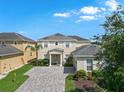 Charming two-story home with lush landscaping and a brick paver driveway at 5819 Covington Cove Way, Orlando, FL 32829