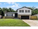 Charming two-story home with stone accents, a well-manicured lawn, and a black garage door at 608 Pearl Rd, Winter Springs, FL 32708