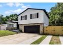 Well-maintained two-story home showcasing stone accents, black shutters, and a black garage door at 608 Pearl Rd, Winter Springs, FL 32708