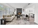 Bright living room featuring a stone fireplace, large windows, and modern furnishings at 608 Pearl Rd, Winter Springs, FL 32708