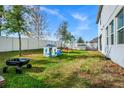 Large grassy backyard with white fence, playset, and mature trees at 609 Big Pine Ave, Minneola, FL 34715