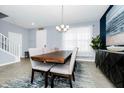 Dining room with a wood table, six chairs, modern chandelier, and decorative rug at 609 Big Pine Ave, Minneola, FL 34715