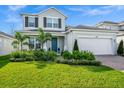 Charming two-story home featuring lush landscaping, brick driveway and two car garage at 609 Big Pine Ave, Minneola, FL 34715