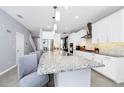 Bright kitchen with an island, white cabinets, granite countertops, stainless steel appliances, and pendant lighting at 609 Big Pine Ave, Minneola, FL 34715