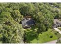 An aerial view showing this home nestled among mature trees on a large lot at 643 Princewood Dr, Deland, FL 32724