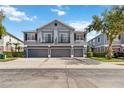 Stylish townhome featuring a gray exterior, multiple garage doors, and quaint second-story balconies at 6484 S Goldenrod Rd # 41A, Orlando, FL 32822