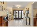 Bright foyer with tile flooring, statement mirror, and beautiful double door entryway that welcomes guests at 708 Valencia Ct, Winter Garden, FL 34787