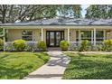 Inviting walkway leading to the home's entrance, featuring double front doors, a covered porch and meticulous landscaping at 708 Valencia Ct, Winter Garden, FL 34787