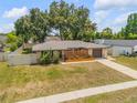 Aerial view of a charming single-story home with fenced yard, mature trees and a private driveway at 879 Tamerlane St, Deltona, FL 32725