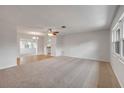 Spacious living area filled with natural light, neutral carpet, and view of the dining and kitchen areas at 879 Tamerlane St, Deltona, FL 32725