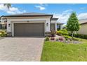 Home exterior with a large two car garage, paver driveway, and meticulously maintained front yard at 971 Braewood Dr, Clermont, FL 34715