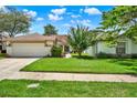 Beautiful house with a well-maintained lawn, complemented by lush landscaping and a clean driveway at 11548 Pumpkin Seed Ct, Orlando, FL 32821