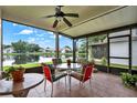 Relaxing screened-in porch features comfortable seating, a ceiling fan, and a beautiful view of the lake at 11548 Pumpkin Seed Ct, Orlando, FL 32821