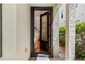 Elegant front door with decorative glass and dark trim, opening to reveal hardwood floors and a staircase at 1615 Wilson Ave, Orlando, FL 32804