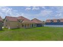Expansive backyard view showcasing green lawn and covered patio perfect for outdoor entertaining at 1919 Sipes Ave, Sanford, FL 32771