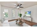 Bright living room with white walls, wood floors, ceiling fan, and modern furnishings at 2058 Prospect Ave, Orlando, FL 32814