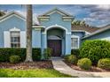 Inviting home entrance with a manicured lawn, and arched front door at 2237 Wintermere Pointe Dr, Winter Garden, FL 34787