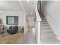 Inviting foyer featuring tile flooring, a staircase, and stylish decor at 2355 White Lilly Dr, Kissimmee, FL 34747