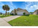 Spacious home with a two-car garage, complemented by lush green landscaping and a long driveway at 2546 Oneida Loop, Kissimmee, FL 34747