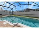 Screened-in pool with clear blue water, surrounded by a white fence and green landscaping at 2546 Oneida Loop, Kissimmee, FL 34747