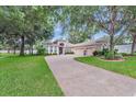 Inviting exterior with a brick driveway, lush landscaping, and a two-car garage at 2579 Woodside Ridge Dr, Apopka, FL 32712