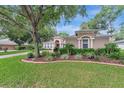 Beautifully landscaped front yard with mature trees and tasteful plantings at 2579 Woodside Ridge Dr, Apopka, FL 32712