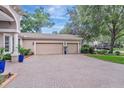 Spacious three-car garage with brick driveway and well-maintained landscaping at 2579 Woodside Ridge Dr, Apopka, FL 32712